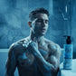 U&I Men in Blue bath and shower gel bottle next to a man with soapy skin in a moody, blue-lit bathroom setting.