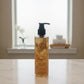 U&I Oud Bath & Shower Gel in a 200ml clear pump bottle with golden liquid, displayed on a marble surface.
