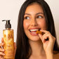 U&I Oud bath and shower gel in a 200ml pump bottle held by a smiling woman eating a caramel candy.
