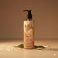 U&I Oud bath and shower gel in a 200ml pump bottle with warm amber tones, surrounded by flower petals.
