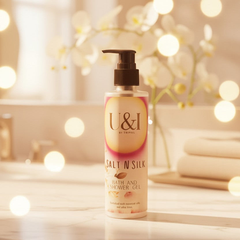 U&I Salt N Silk bath and shower gel bottle with floral design on a marble bathroom counter with soft bokeh lighting.