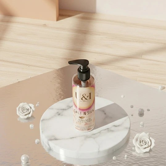 U&I Salt N Silk perfumed body lotion in a clear pump bottle on a marble pedestal with white roses and pearls.