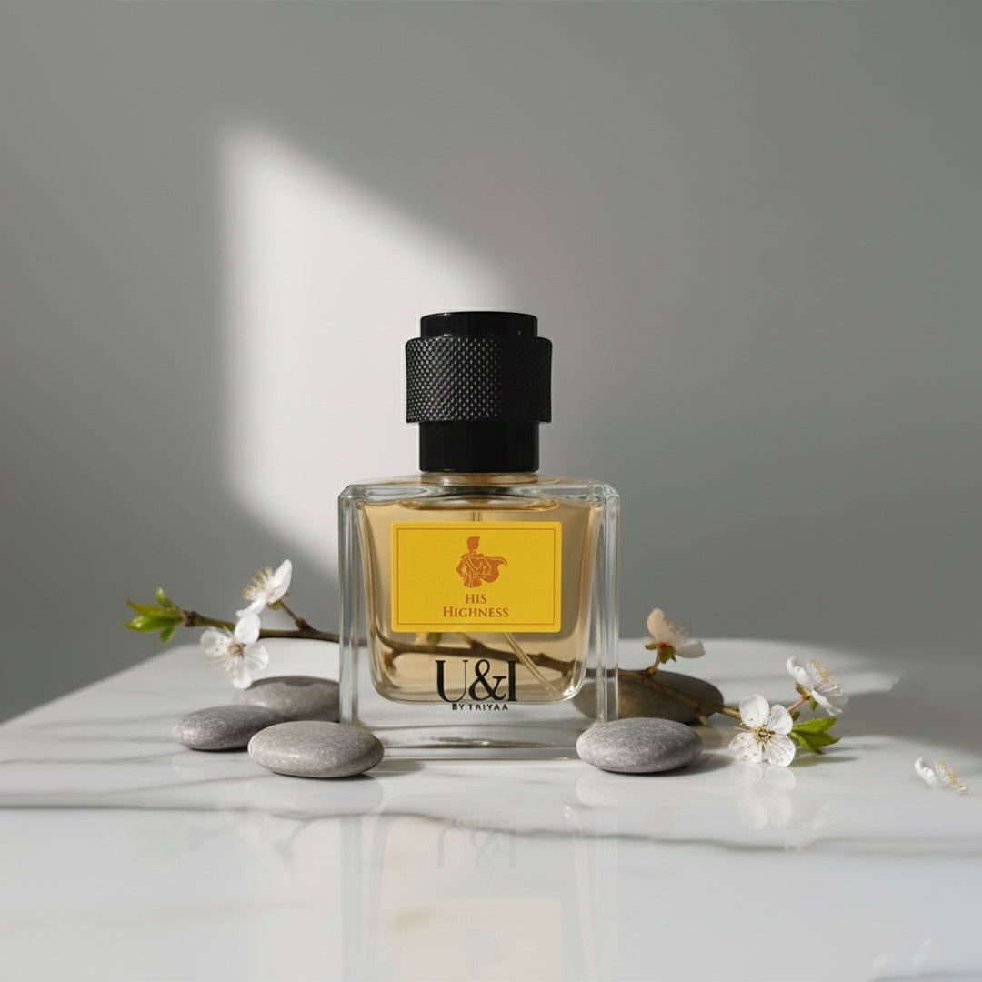 U&I His Highness fragrance bottle with yellow label, black cap, and white flowers on a marble surface.