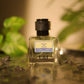 U&I Ruling the Ocean perfume bottle with a textured black cap, set in shallow water with soft green foliage background