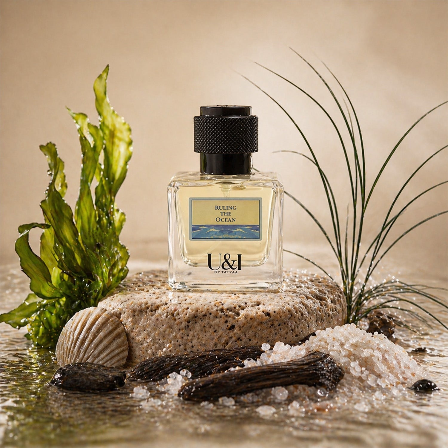 U&I Ruling the Ocean fragrance bottle on a stone with sea salt, driftwood, and seaweed against a sandy background.